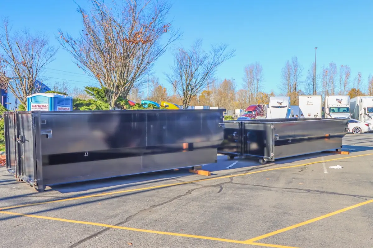 Professional dumpster rental service with roll-off container on residential driveway in Corcoran